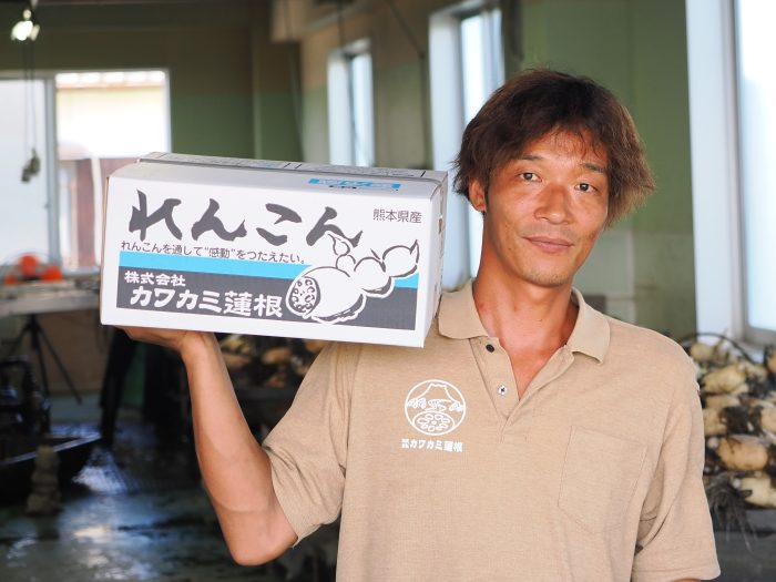 「れんこんを通して感動を伝えたい」と書かれた出荷箱を掲げるスタッフ